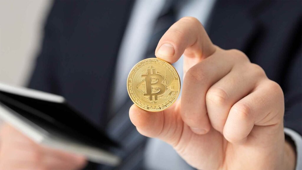 homem segurando um bitcoin