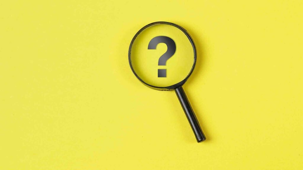 business-financial-concept-with-magnifying-glass-question-mark-yellow-background-flat-lay