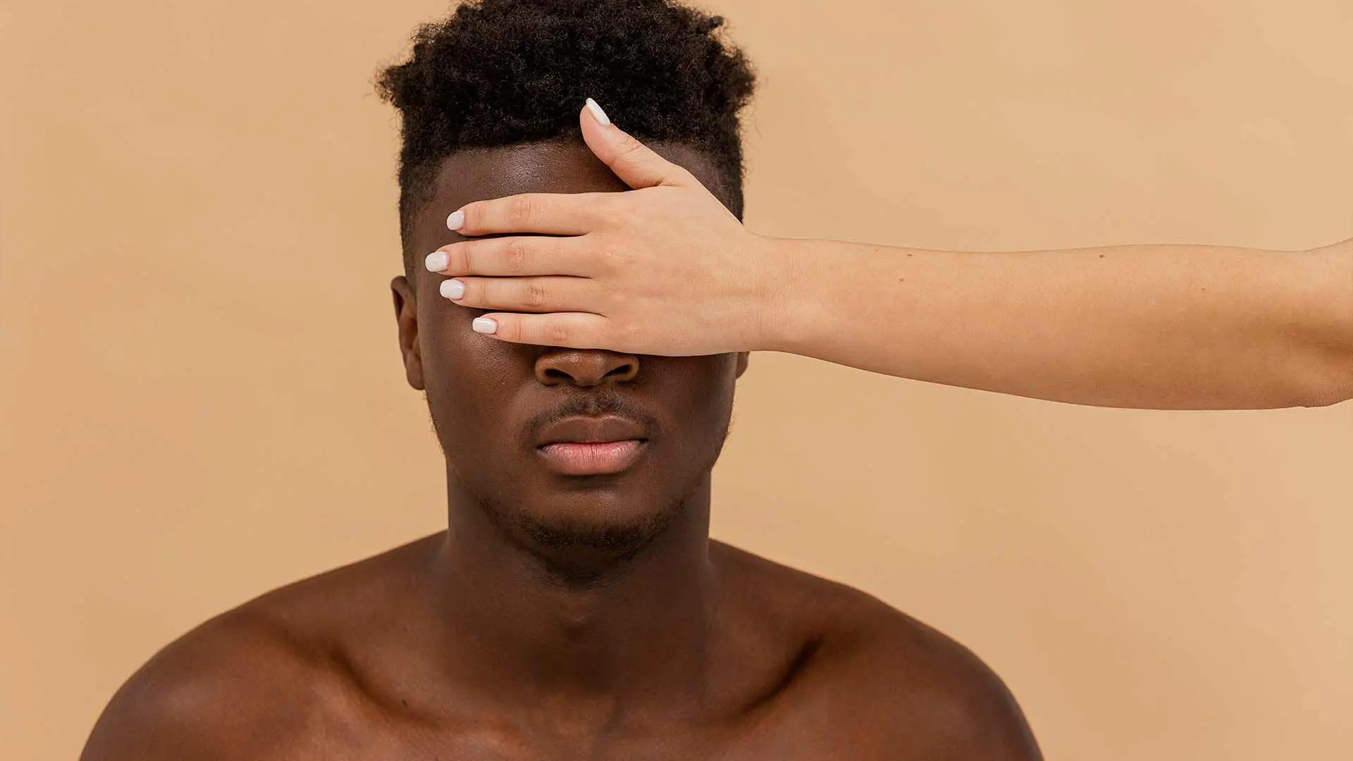 closea-up-white-hand-covering-black-man-eyes