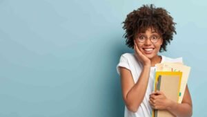 pleasant-looking-afro-american-woman-holds-notepads-papers-studies-college-glad-finish-studying