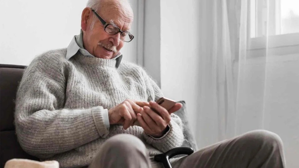 side-view-older-man-nursing-home-using-smartphone