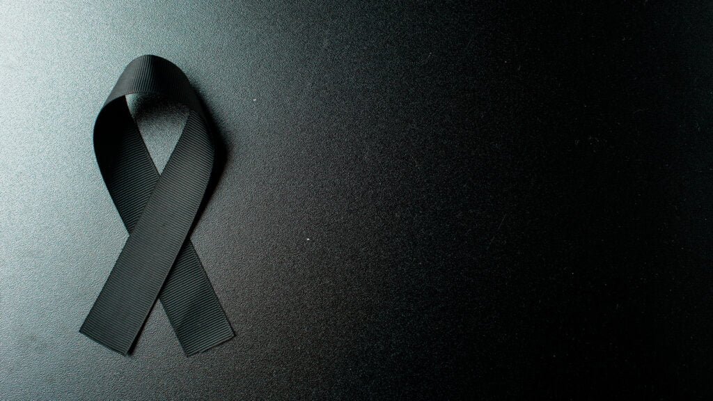 top-view-black-bow-as-mourning-symbol-dark-wall