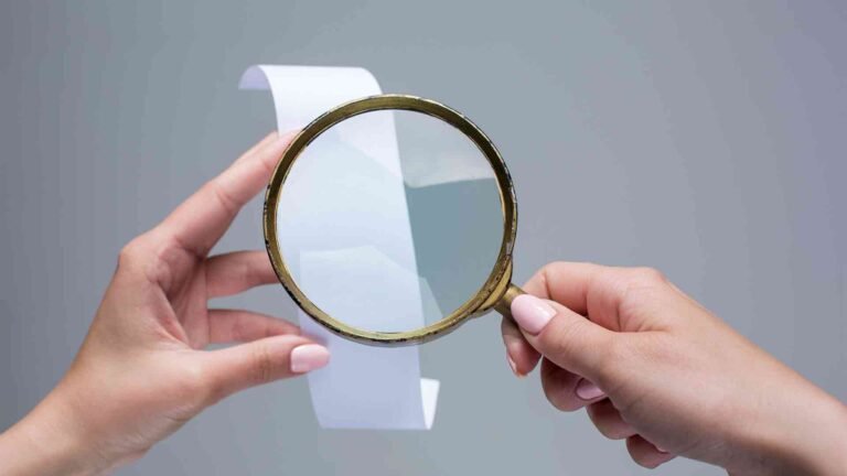 female-hands-with-empty-transaction-paper-check-magnifier