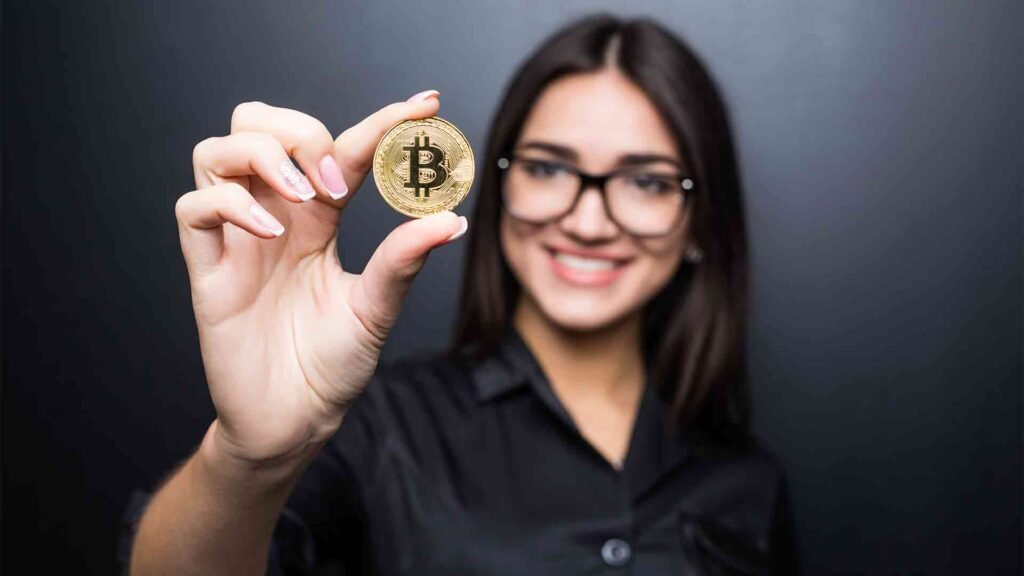 young-successful-confident-woman-with-glasses-holds-gold-bitcoin-her-hand-isolated-black-wall