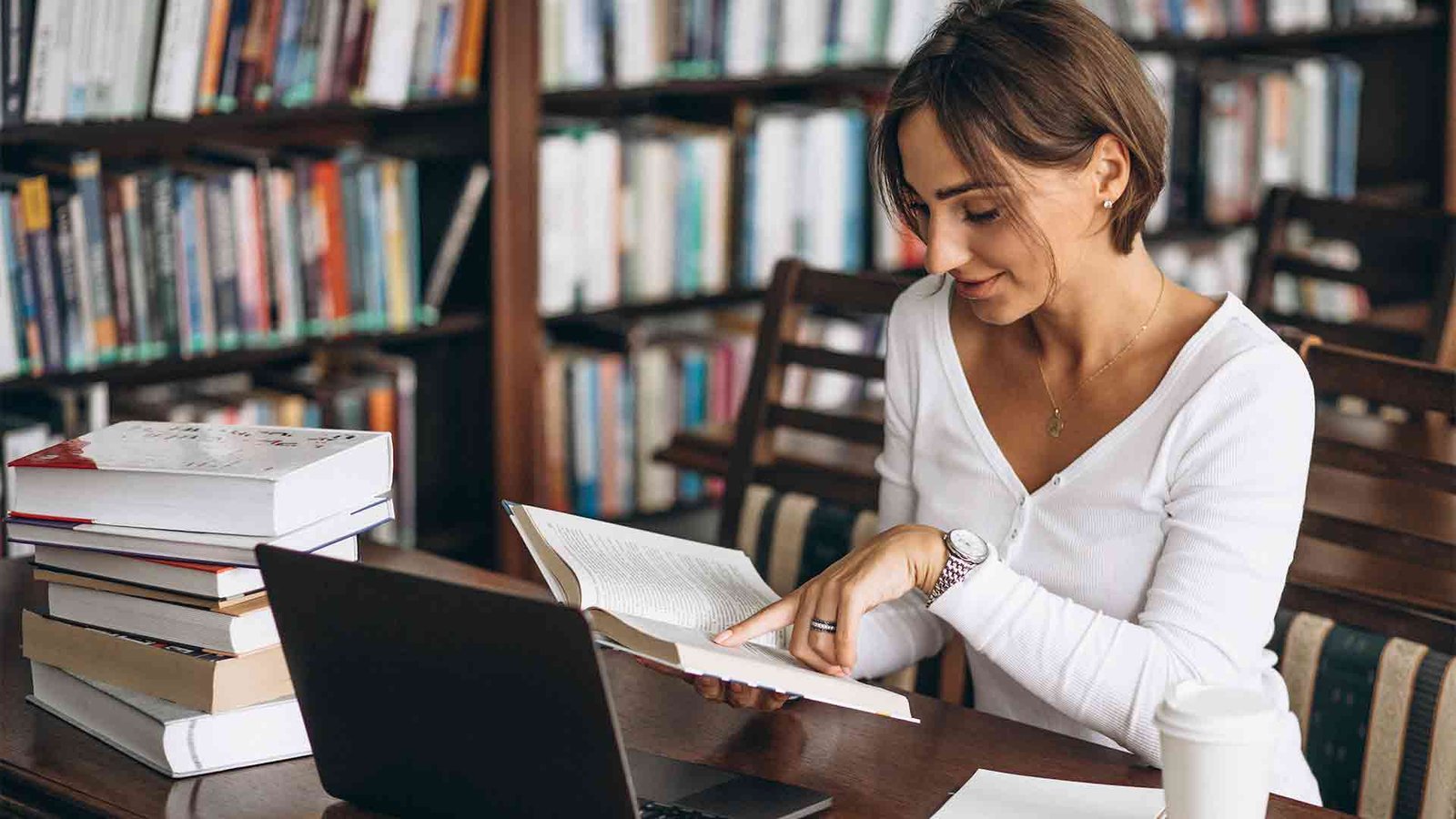 young-woman-sitting-library-using-books-computer