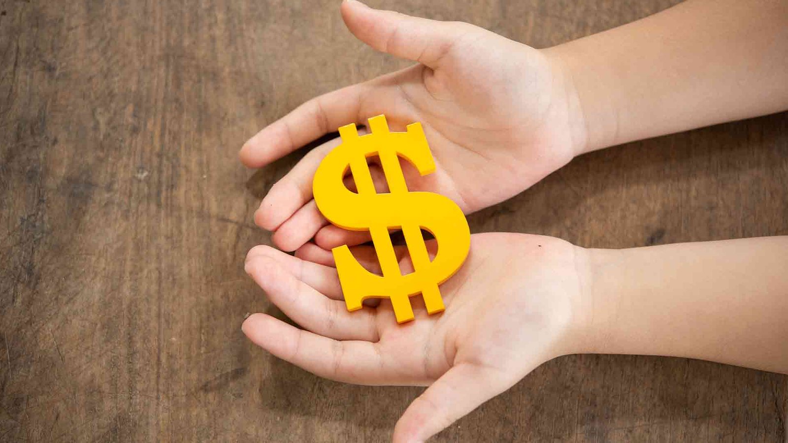child-holding-yellow-dollar-sign