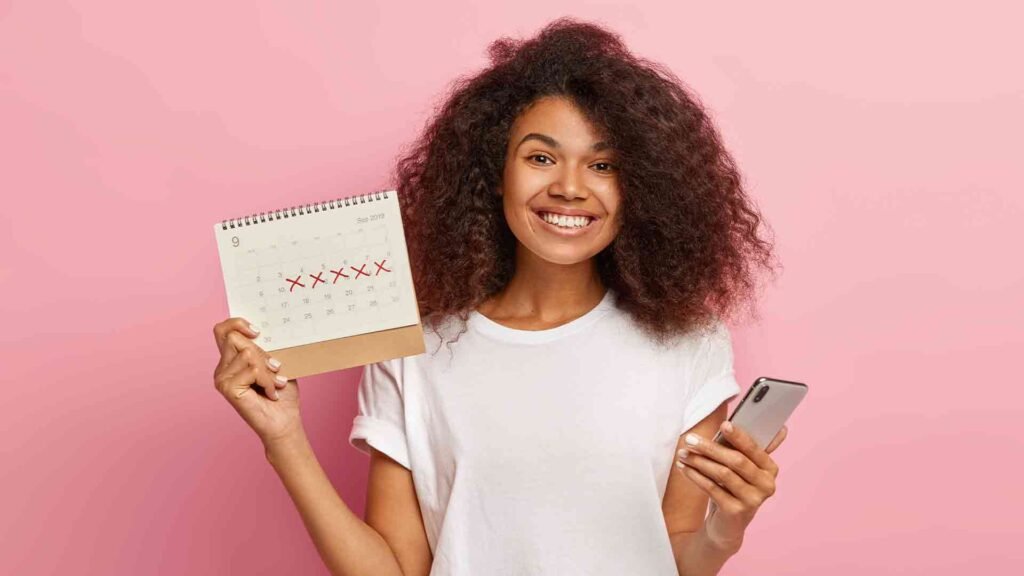 happy-curly-woman-holds-periods-calendar
