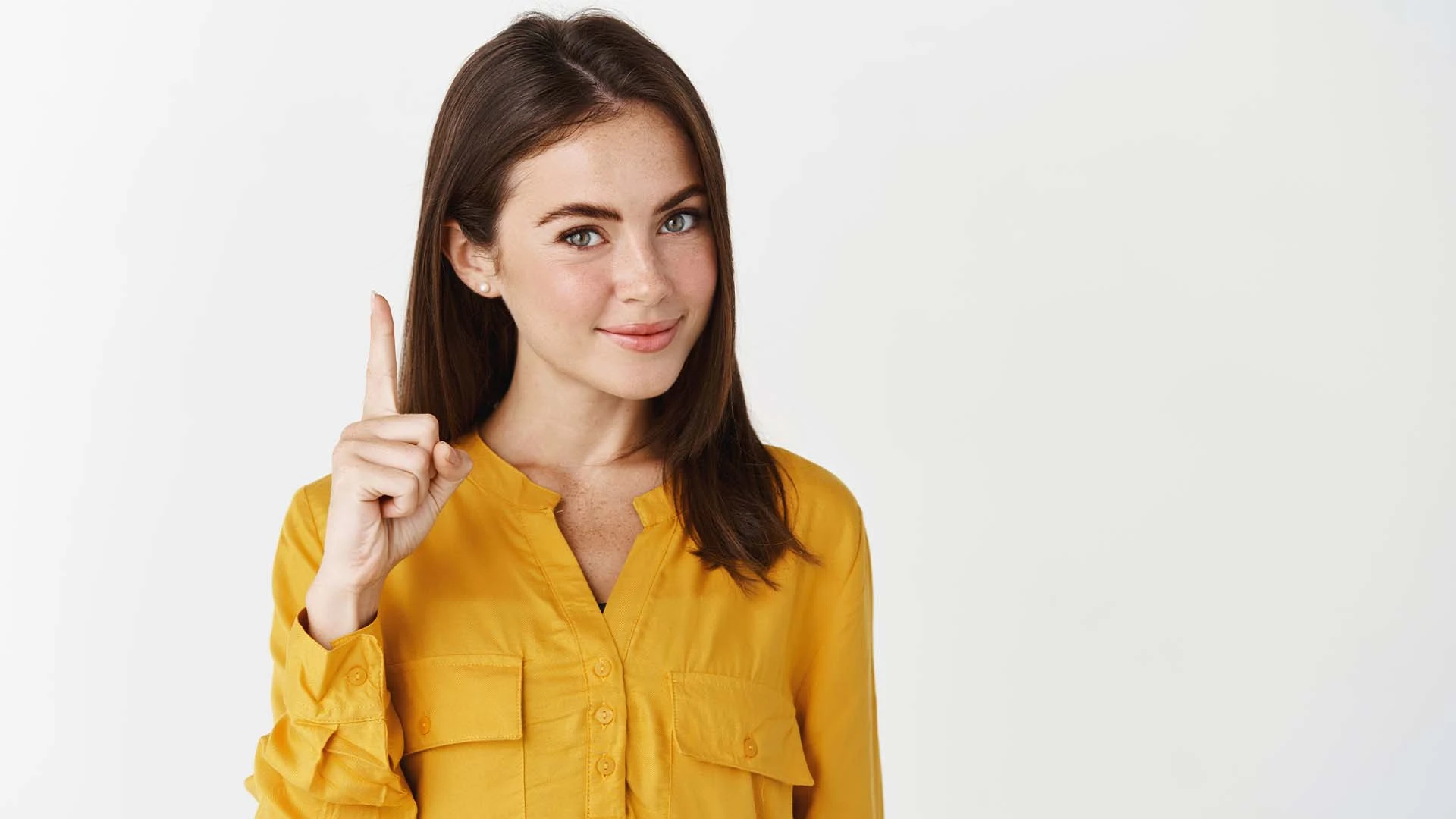 young-thoughtful-woman-showing-advertisement-pointing-finger-up-smiling-front-giving-knowing-look-st